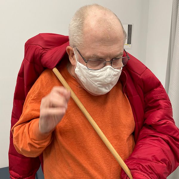 Professional Rehab Patient learns to put on coat during occupational therapy session